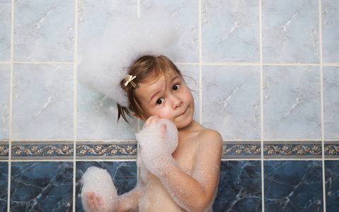 小女孩一场泡泡浴。卫生保健和卫生的概念