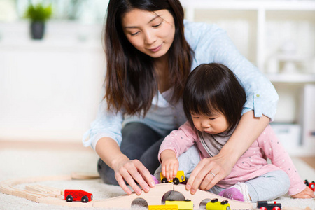 很高兴日本母亲玩她小小的蹒跚学步的女儿