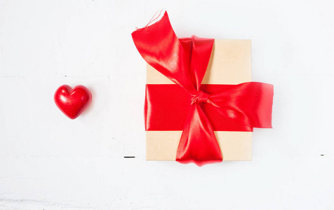 礼物或红色蝴蝶结缎带和陶瓷心的情人节那天木制的桌子上的礼物箱