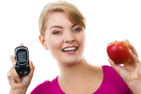 幸福的女人控股血糖仪和新鲜苹果，测量和检查糖水平，糖尿病的概念