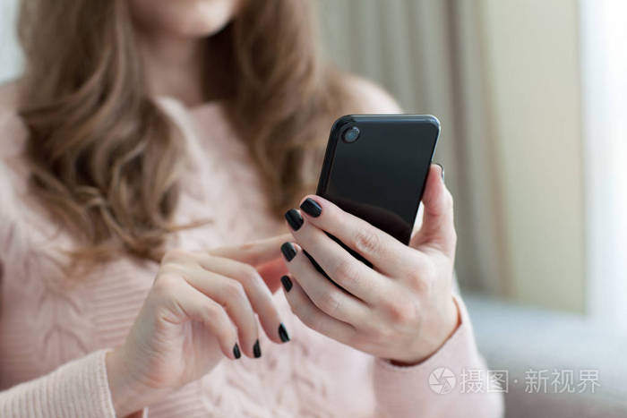 女人抱着黑色触摸手机
