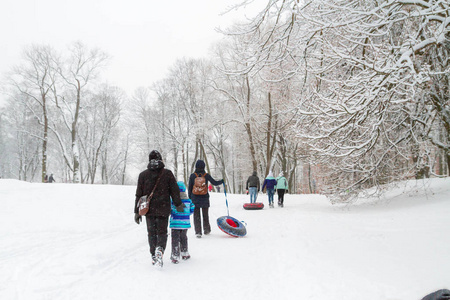 人在冬季公园在雪中散步