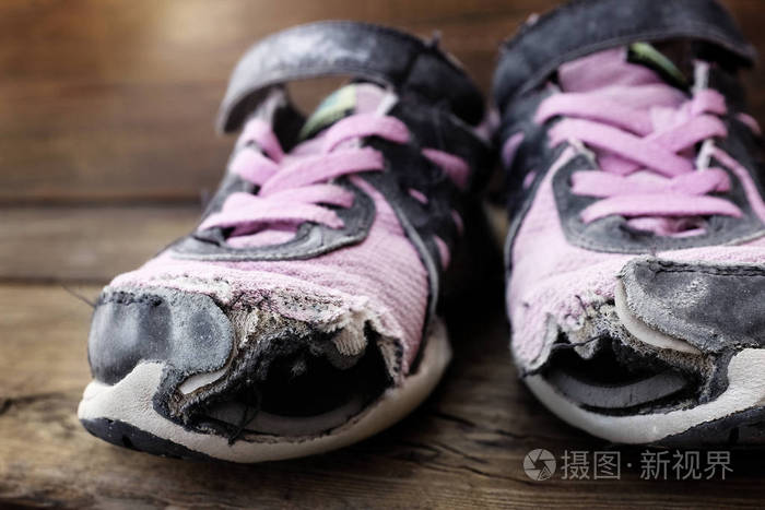 破旧的旧鞋孔在脚趾无家可归的孩子