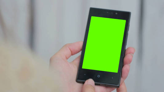 女人看着绿屏智能手机图片