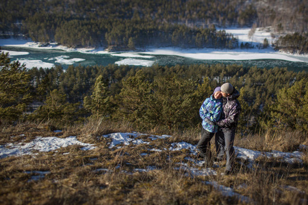 在冬天，阿勒泰，俄罗斯在一块岩石上拥抱对年轻的夫妇