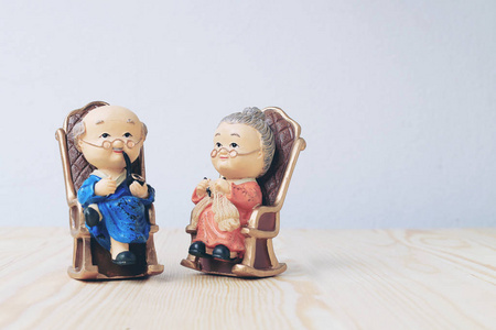 奶奶和爷爷的娃娃在中国统一的风格站在木制的背景。在中国农历新年