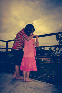 爱观点后面的观点的亚洲兄弟把某人的胳膊搂着姐姐的肩膀.