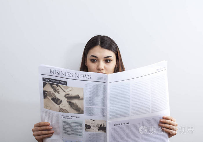 灰色的背景上看报纸的女商人
