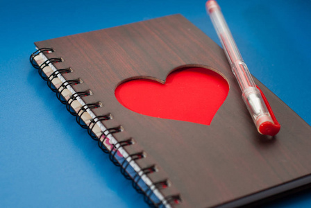 一本笔记本，在蓝色背景上大红色的心