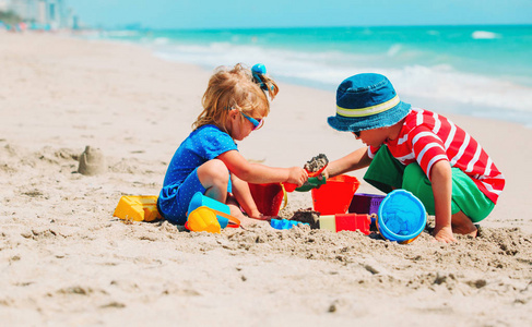 孩子们在夏天的海滩上玩沙子