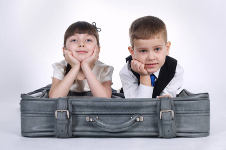 小男孩和女孩躺在行李箱上图片