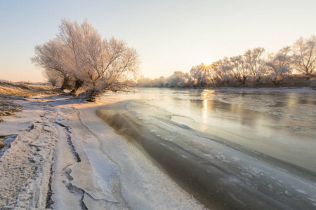 美丽的冬天风景树木受霜冻，沿着冰冻的河