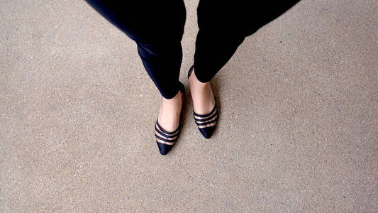 时尚女性黑鞋子的特写。在地板上的鞋