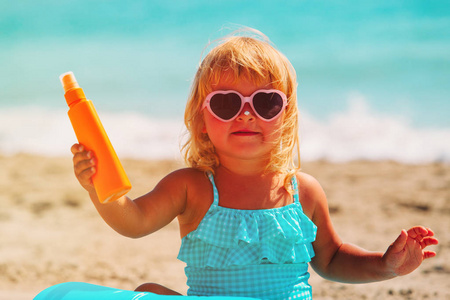 太阳保护概念   在海滩防晒的小女孩