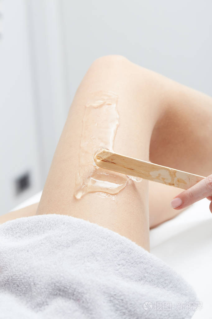 在沙龙有腿激光脱毛治疗的年轻女人