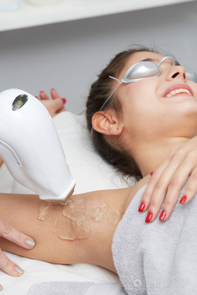 在沙龙有腋下激光脱毛治疗的年轻女人