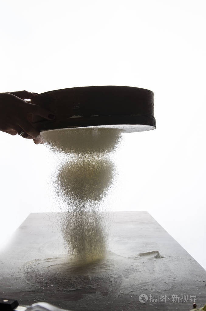 女人筛面粉与美丽的光