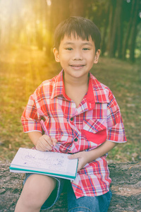 快乐的亚洲男孩微笑着拿着一本书。教育理念。复古风格