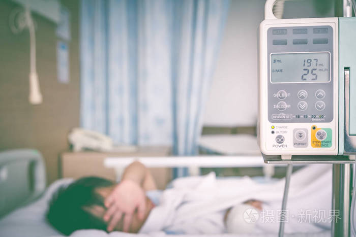 亚洲男孩躺在病床上输液泵静脉点滴