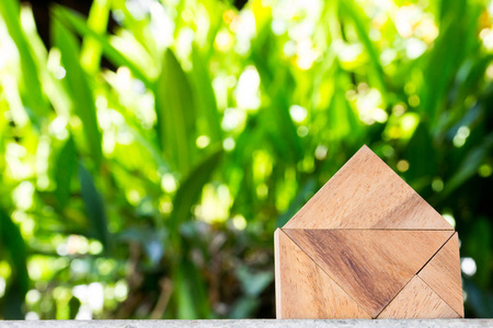 木制玩具作为梦想的房子概念模糊的绿色背景
