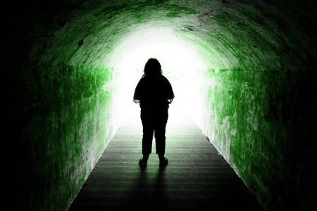 女人站在隧道尽头的剪影