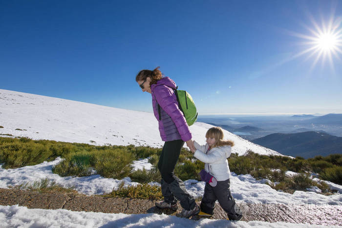 母亲和孩子在雪峰山徒步旅行