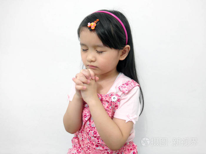 可爱的小亚洲女孩闭着眼睛双手祈祷关闭
