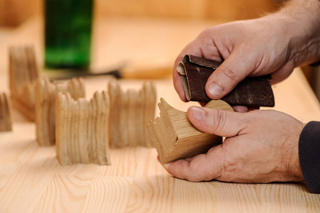 抛光用砂纸打磨木头的木匠手照片