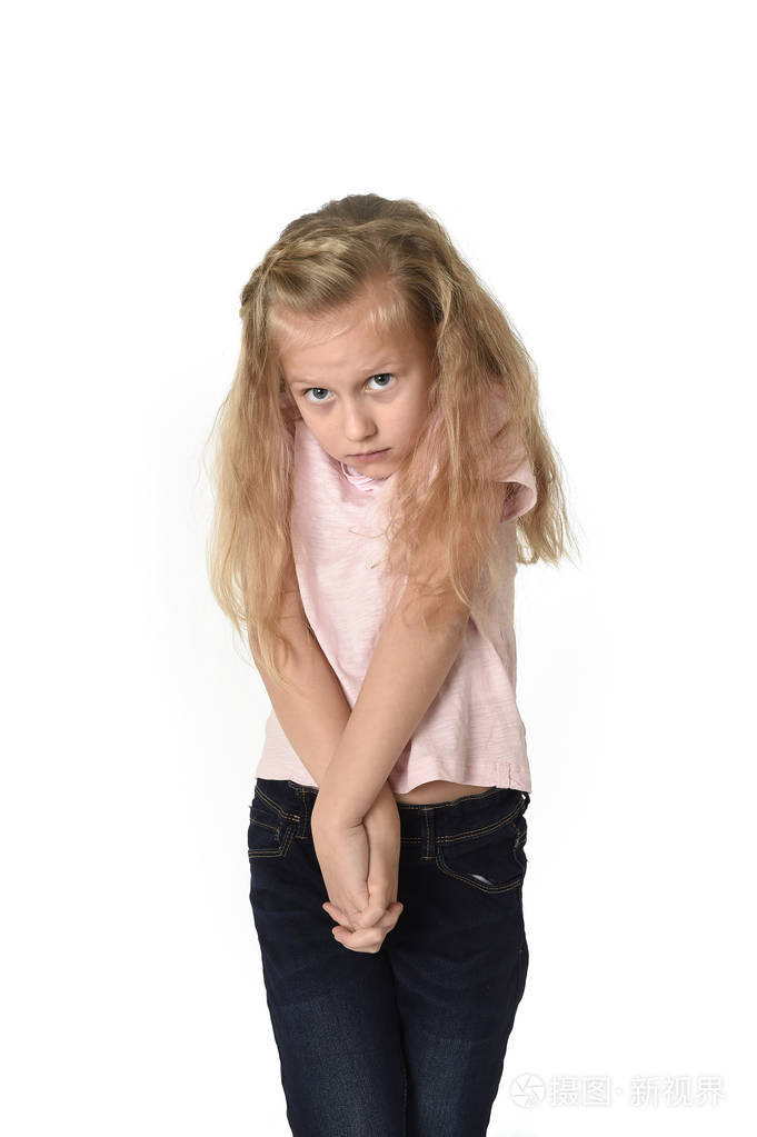 可爱的孩子的小姑娘着美丽的金色的头发,穿着休闲服看害羞, 胆小怕事