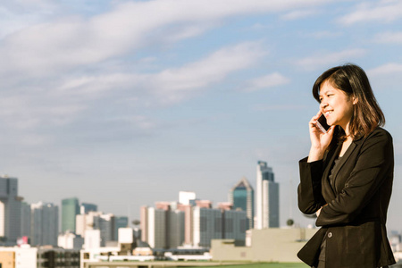 亚洲美丽的商务女性在现代建筑，电信业务电话