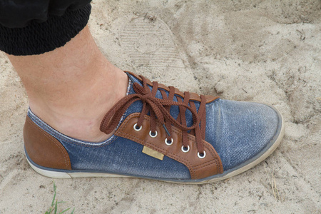 牛仔鞋在沙漠中的沙滩上图片