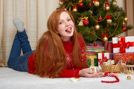 在圣诞节装饰的漂亮女孩。家庭室内装饰的枞树和礼物。新年前夕和冬季假日概念