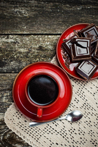 红杯咖啡，巧克力对木制件表背景。有色。顶视图