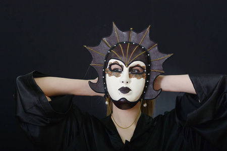 在一块戏剧面具的美丽金发女郎照片