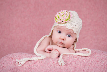新生女婴在温暖的针织帽，有一朵花