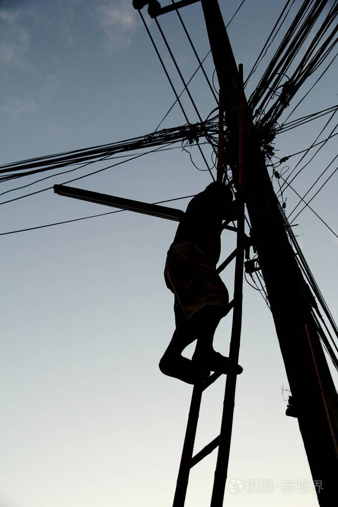 爬上木制楼梯的人爬上灯