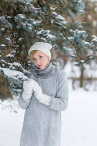 美丽的女孩在一顶白色的帽子和手套在冬天下雪天佛