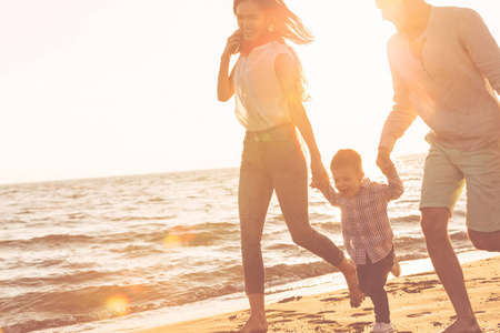 年轻的家庭在海滩上找到乐趣