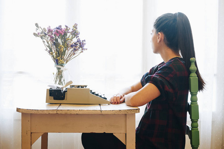 年轻女子在老式打字机上打字