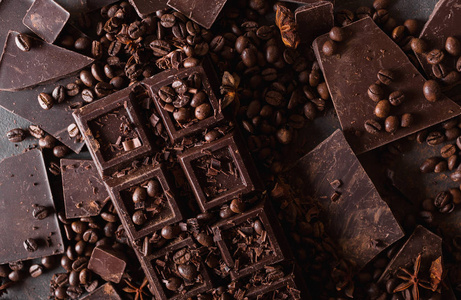 巧克力，咖啡豆。和可可粉。巧克力碎片。黑巧克力的背景。一大块巧克力灰色抽象背景