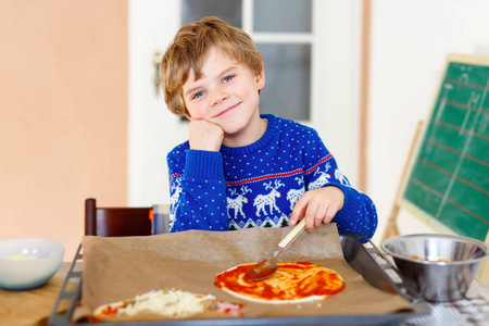 可爱的孩子小男孩做新鲜的蔬菜与意大利比萨