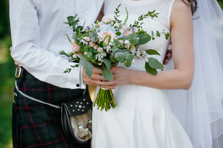 新娘和新郎抱着一束。婚礼鲜花