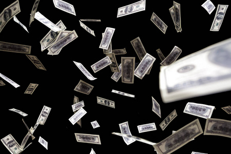 一百美元钞票飞在黑色背景上.钱雨概念照片