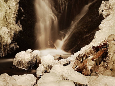 冰冻的瀑布。冬溪 冰冷的石头和树枝