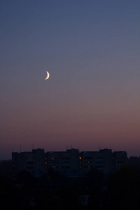 现代城市住宅区夜景天空中的半月