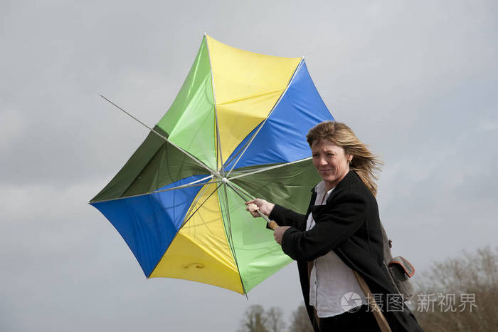 在刮风天拿着雨伞而外的女人照片-正版商用图片0x2mcu-摄图新视界