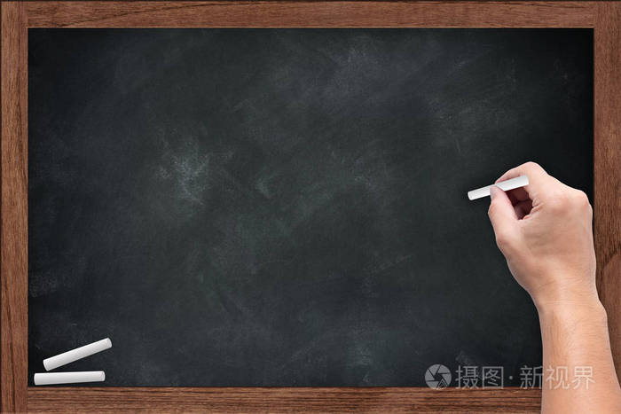 黑板上老师的手举行粉笔在木板上粉笔染脏