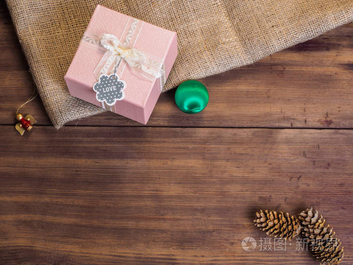 老式的礼品盒，冷杉球果，圣诞玩具，丝带蝴蝶结的木和麻布背景，照片顶视图。复制文本的空间