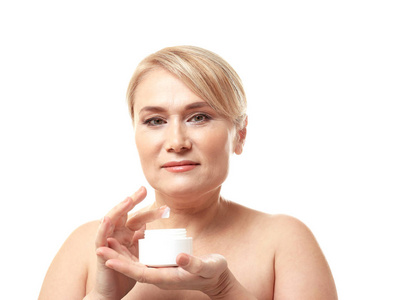 成熟的女人在白色背景上的抗衰老面霜罐