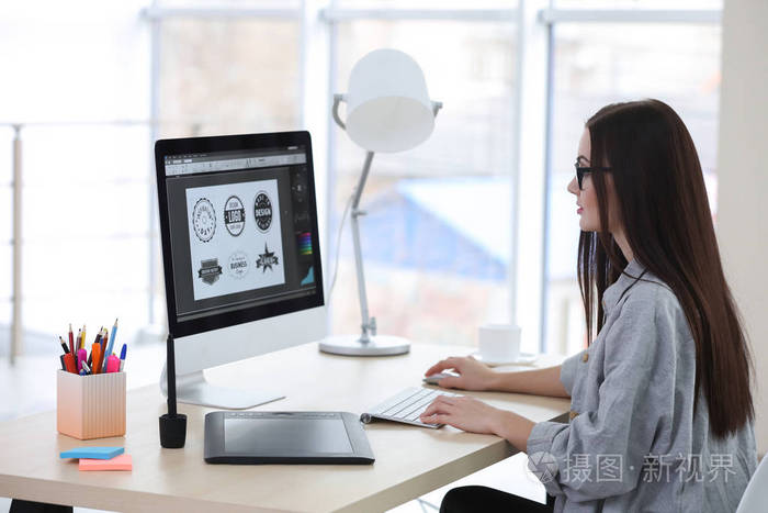 在办公室里工作的年轻女设计师照片-正版商用图片0x3463-摄图新视界